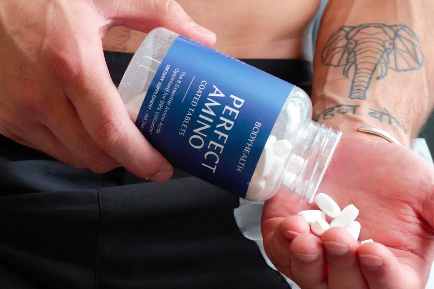 Pouring BodyHealth Perfect Amino tablets into an open palm