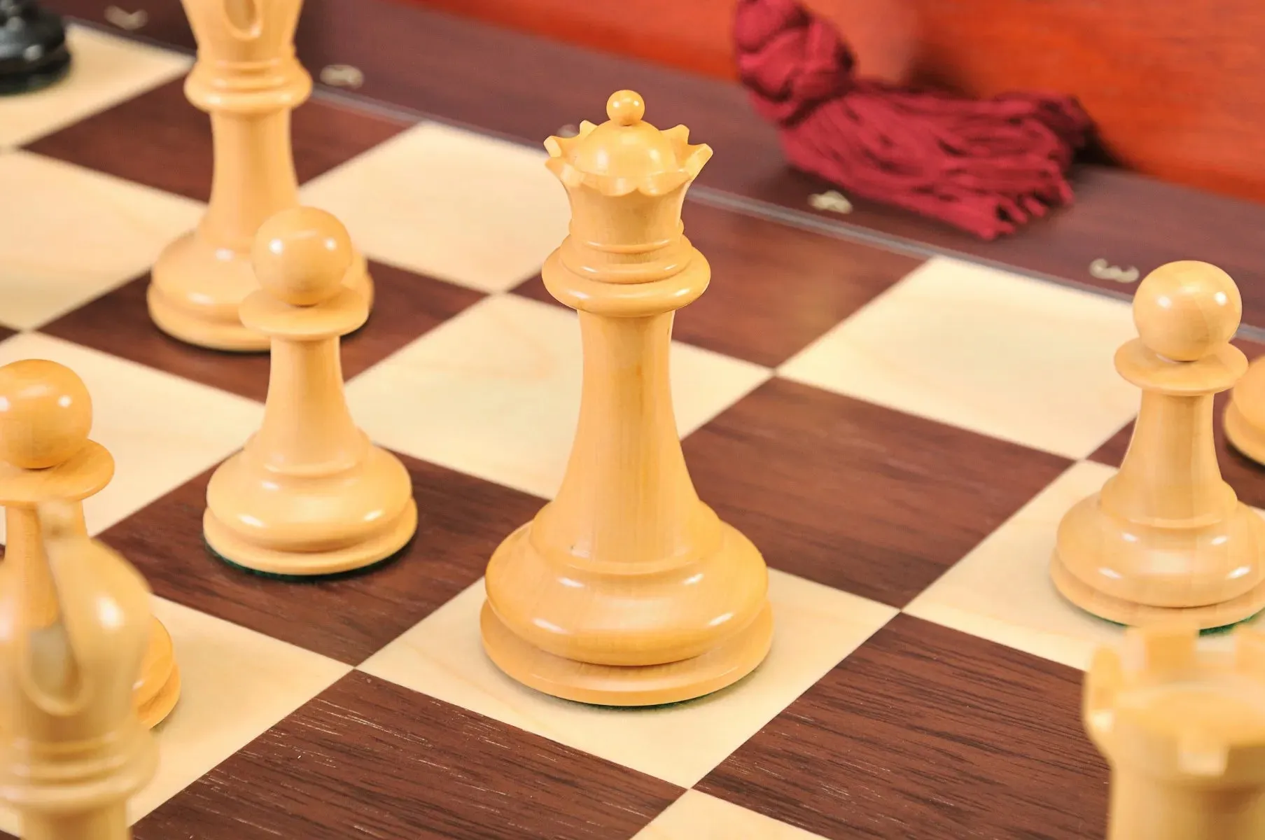 A boxwood queen on a wooden board from a House of Staunton chess set