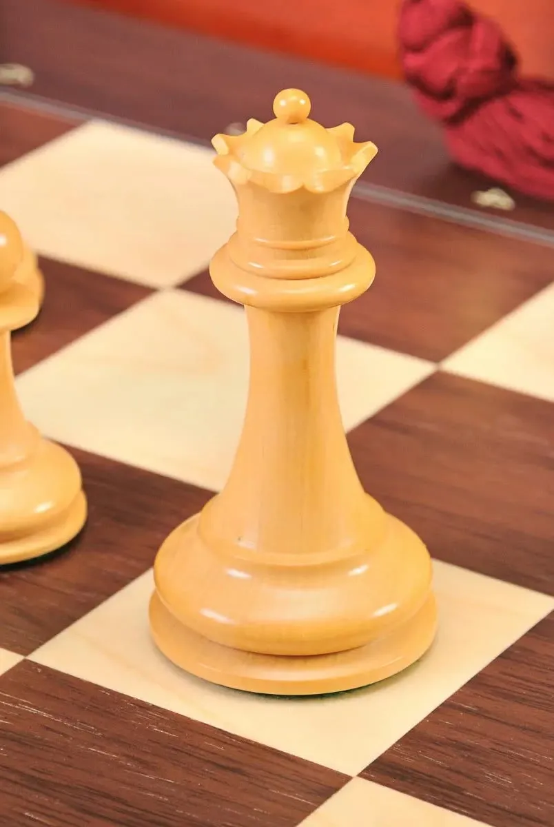 A boxwood queen standing on a wooden board from a House of Staunton chess set